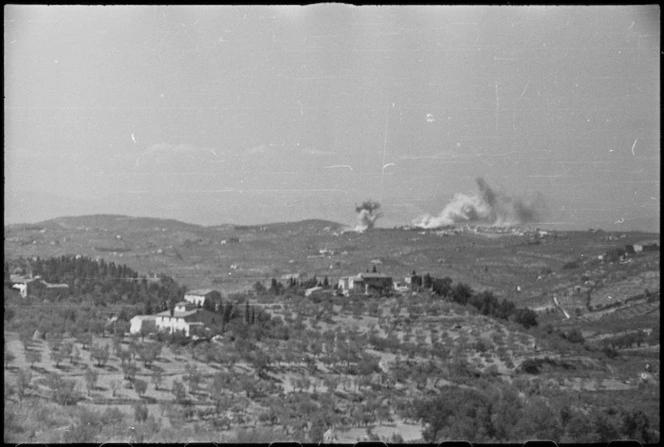 Smoke from bombs and shells visible over the enemy stronghold of San Casciano in Italy, during World War II - Photograph taken by George Kaye