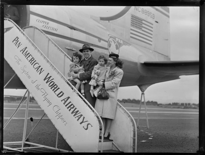 Portrait of Mr and Mrs Rouda and family boarding PAA Clipper Celestial NC 88959 passenger plane, Whenuapai Airfield, Auckland