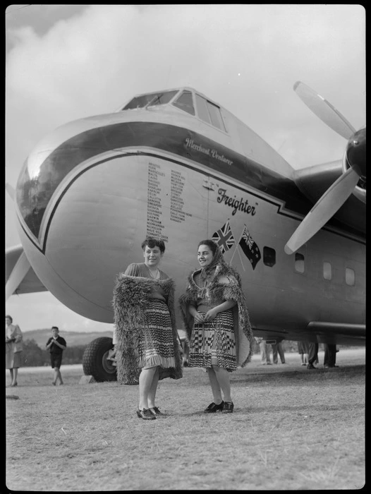 Bristol Freighter tour, Rotorua, showing Guide Bubbles and Guide Emily, wearing Maori cloaks and piupiu skirts, including a Bristol Freighter 'Merchant Venturer' aircraft with a list of airports visited painted on the nose and a British and New Zealand flag