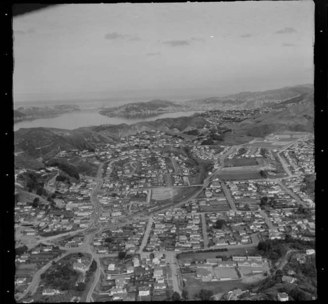 View over the Wellington City northern suburb of Johnsonville and Johnsonville Primary School in foreground to the Railway Station and Southern Motorway, with Wellington Harbour beyond
