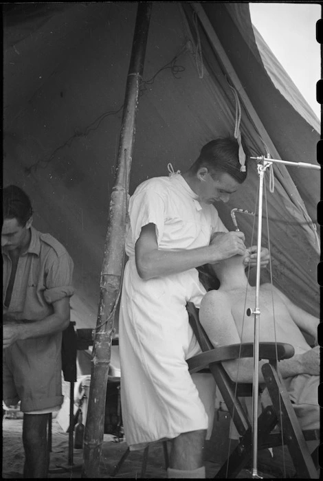 E D Wilson given dental treatment by dental Officer, Captain W Simmers, in Italy, World War II - Photograph taken by George Kaye