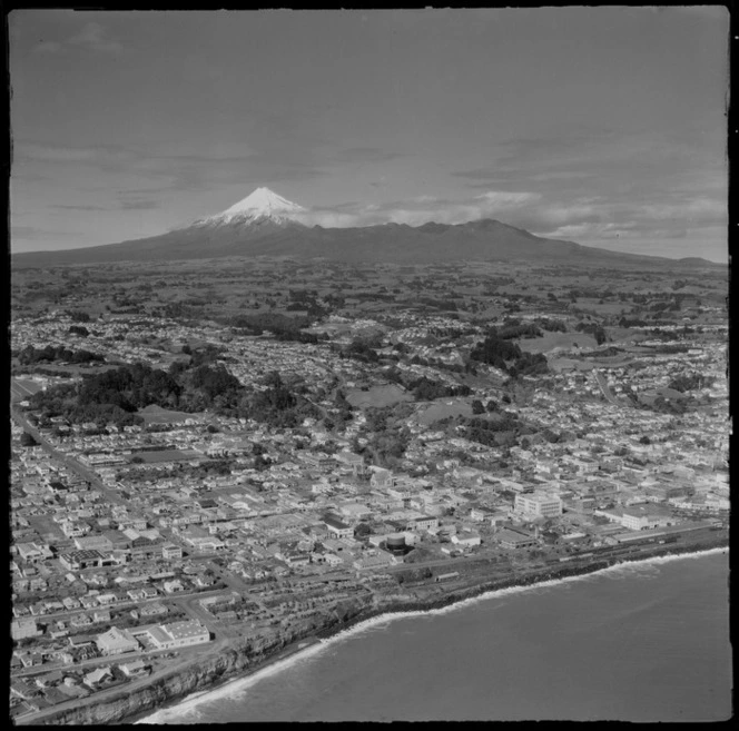 View inland over New Plymouth City waterfront with railway station and Pukekura Park to the suburbs of Vogeltown and Ferndale, with farmland and Mount Taranaki beyond