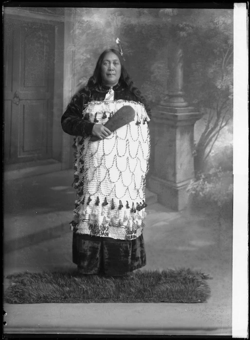 Maori woman with a kiwi feather cloak at her feet