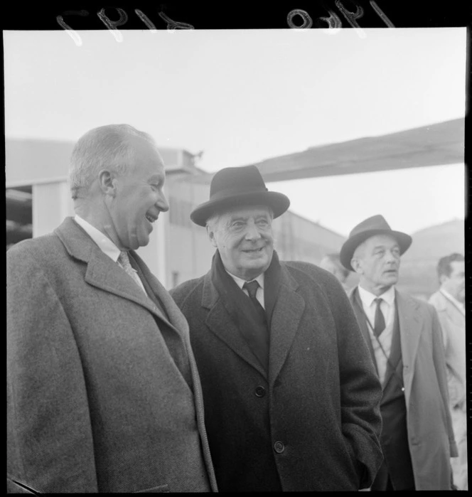 Dr Charles Munch Conductor of the Boston Symphony Orchestra between two unidentified men at [Rongotai Airport?], probably Wellington City