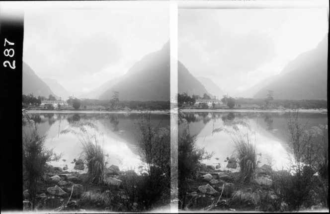 View of lake and house, with mountains in the background, Milford Sound