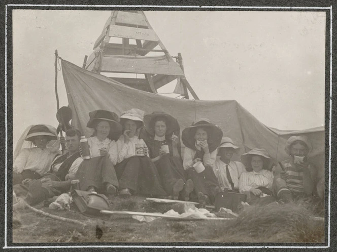 Tramping party having lunch at Mt Holdsworth trig, Tararua Ranges