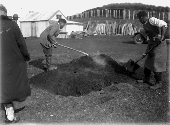 Putting earth over a hangi pit at Parihaka