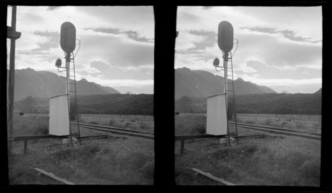 View of a railway line with signal box and forest with the [Mount Avalanche?] mountain range beyond, [Arthurs Pass?], South Island