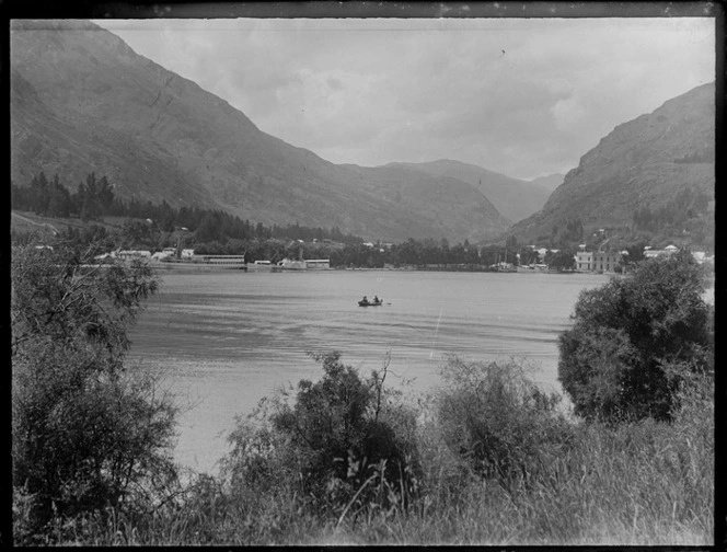 Lake Wakatipu and a group of people in a row boat in front of Queenstown waterfront area with the TSS Earnslaw and Ben Lomond steam boats, Central Otago Region