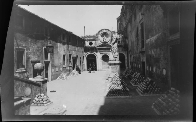 Cannonballs neatly stacked in Castel Sant'Angelo courtyard, with statue on right, Rome, Italy