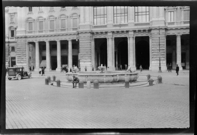 Street view of Fontana di Piazza Colonna including buildings and people walking past, Rome, Italy