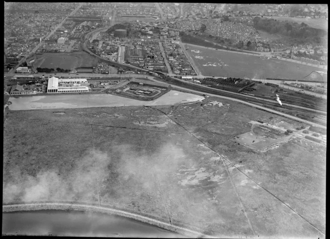 Dunedin City and an unidentified lumber yard next to the harbour area, with Dunedin rail yards and The Oval sports ground beyond, Otago