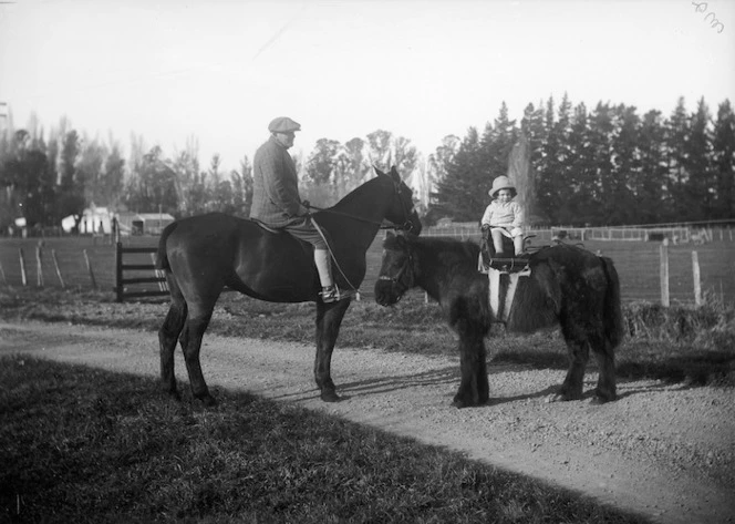 Man on horseback and child on a pony