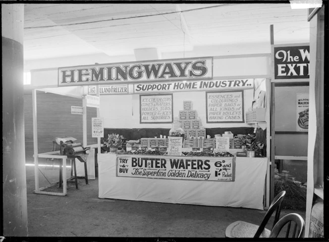 Stall at a trade fair advertising and displaying the produce of J L N Hemingway, including butter wafers and other items associated with ice creams