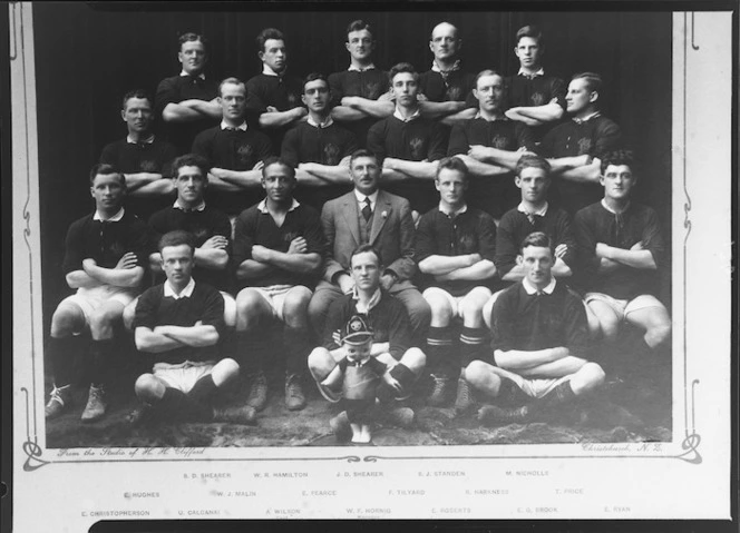 Unidentified rugby team with mascot, including E Christopherson, E Hughes, S D Shearer, U Calcanai, W J Malin, W R Hamilton, A Wilson, E Pearce, J D Shearer, W F Hornig, F Tilyard, S J Standen, R Harkness, M Nicholl - Photograph taken by H H Clifford