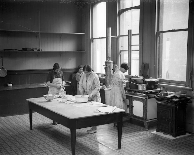 A kitchen with 4 women preparing a meal