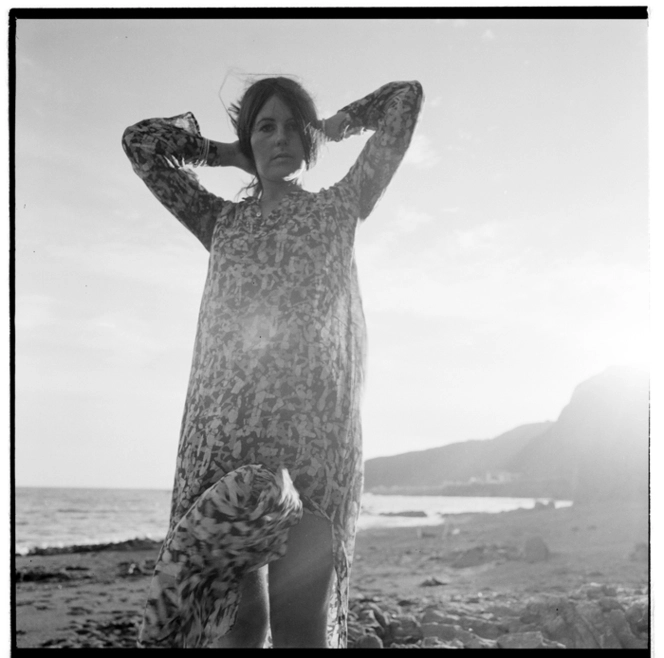 A woman in a transparent kaftan at a beach