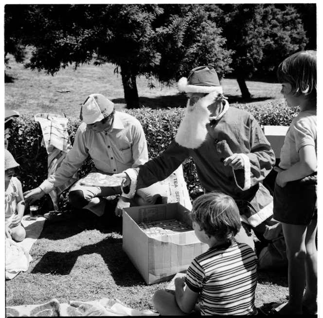 Families celebrating Christmas with a picnic, in a large garden or possibly in a park