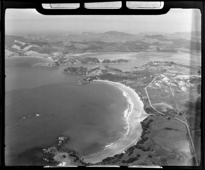 Coopers Beach settlement on the coast of Doubtless Bay with the town of Mangonui and Harbour beyond, Northland
