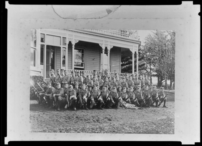 Group portrait of King's College students in military dress holding rifles, Remuera, Auckland