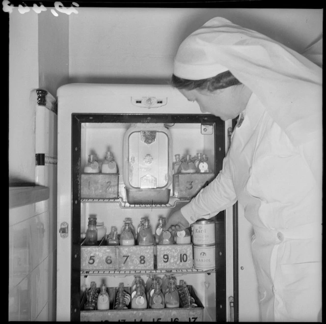 Nurse reaching inside a fridge for babies milk, Karitane Hospital, Christchurch
