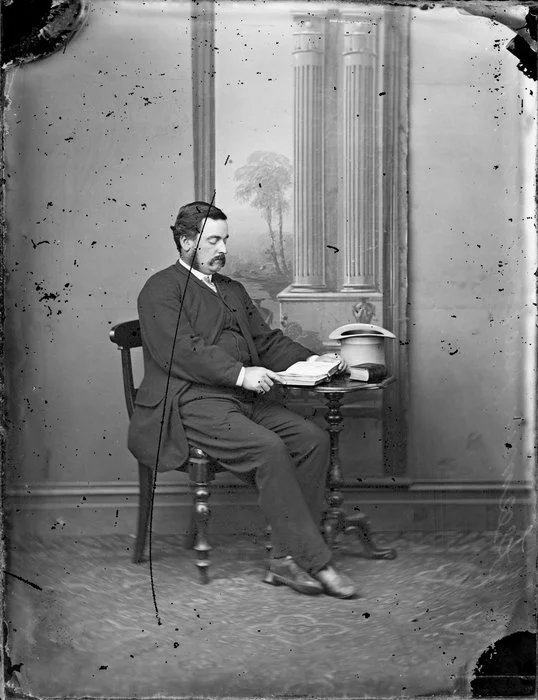 Unidentified man, seated, with an open book