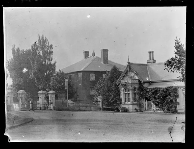 Three-storied brick house and a villa on an Auckland street [and entrance to Albert Park?]