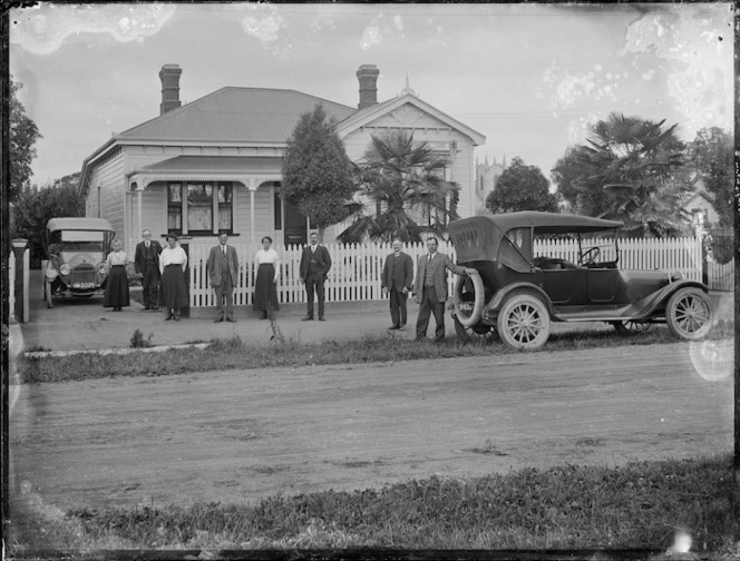 Group and cars outside a house, Hastings