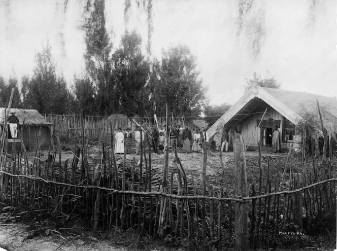People standing next to the meeting house at Maketu Pa, Bay of Plenty