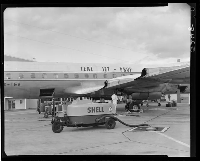 Teal plane on runway with Shell fuel tanker