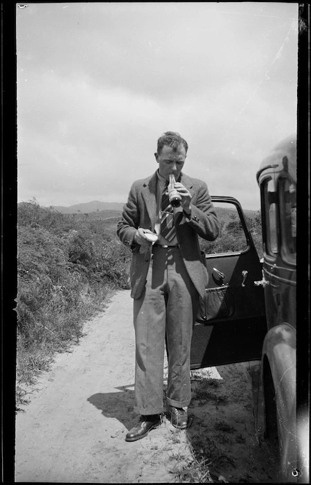 Man standing on roadside beside car