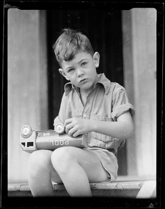 Robert Wells sitting on step with toy truck