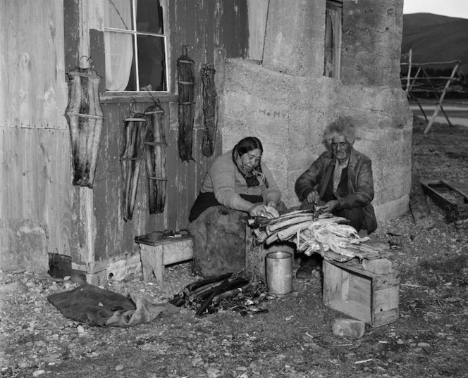 Mrs and Mrs Nutira preparing eels for drying, Lake Forsyth, Canterbury - Photograph taken by K V Bigwood