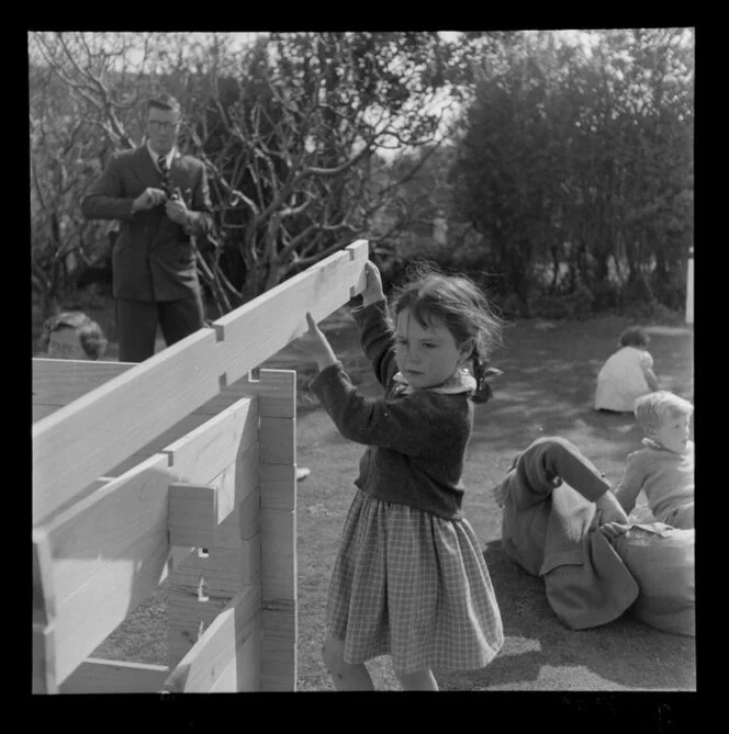 Girl in a playground assembling a wooden structure