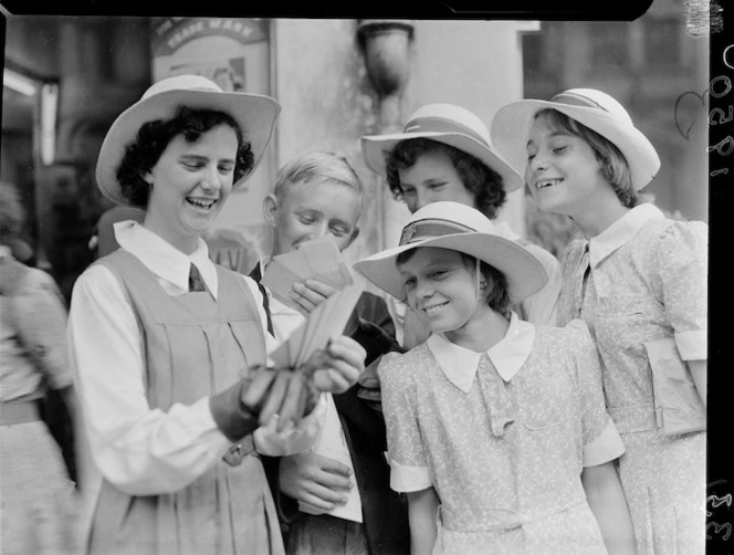 Schoolchildren looking at cards, 1950 British Empire Games, Auckland