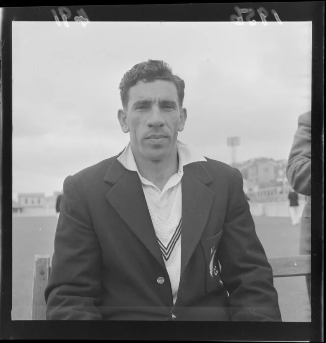 Portrait of an unidentified New Zealand Cricket Team member sitting on a bench in his uniform prior to the third test against the West Indies, Basin Reserve, Wellington Region