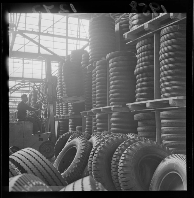 Interior of Dunlop rubber factory, Upper Hutt, showing stacks of tyres