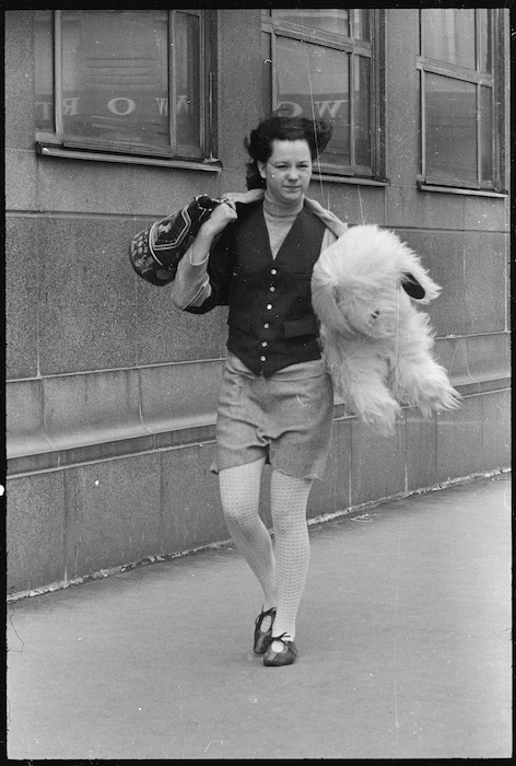 Woman walking into strong wind, Stout Street, Wellington