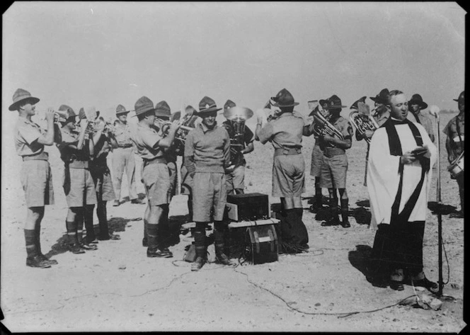 Reverend E B Moore leading New Zealand soldiers in a hymn during an Anzac Day Service during World War 2