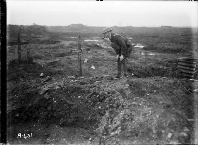 A New Zealand officer reads a cross in a former German field cemetery, World War I