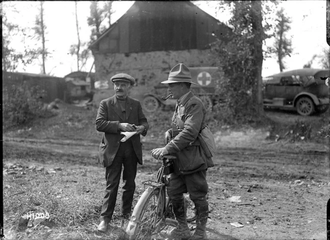 A New Zealand soldier delivers a message to a French villager, Grevillers