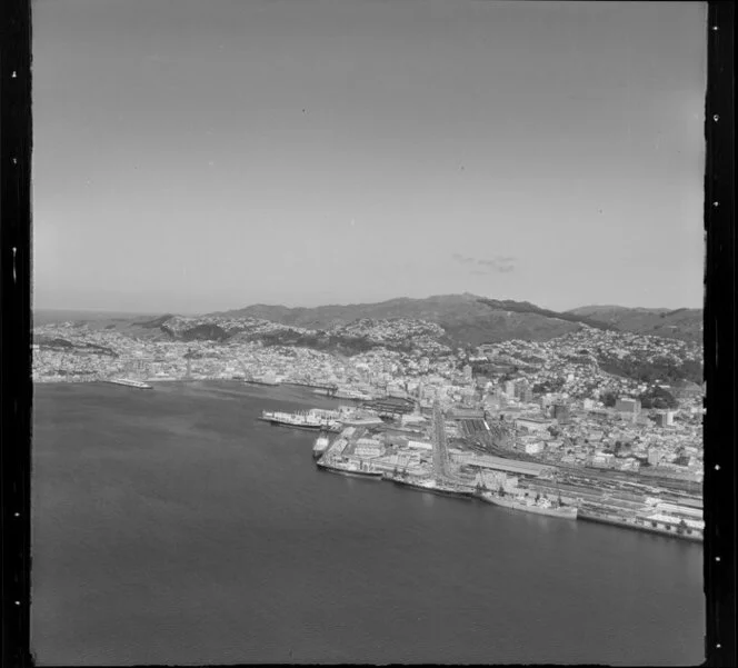 Wellington, city and harbour, featuring ships docked at wharves