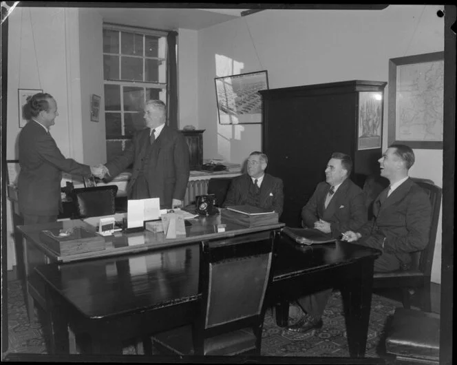 Mr Wallace Townley, manager of Canadian Pacific Airlines (left) shaking hands with Fred Jones, Postmaster General, while Sir Leonard Isitt, Mr E A Gibson and Ian Scott look on