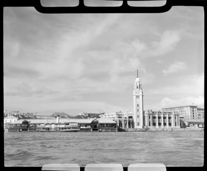 Railway Station, Kowloon, Hong Kong, featuring clock tower, passenger ferry and including advertisments for Carlsberg and San Miguel beers