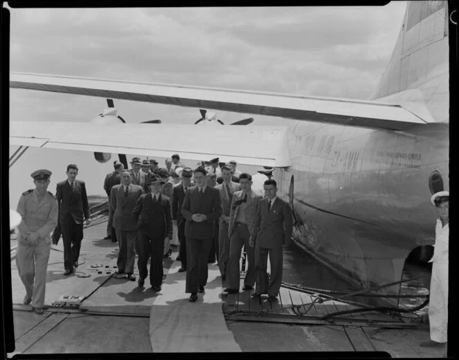 Unidentified passengers leaving the Tasman Empire Airways Ltd Short Solent flying boat RMA Ararangi ZK-AMM, Mechanics Bay, Auckland