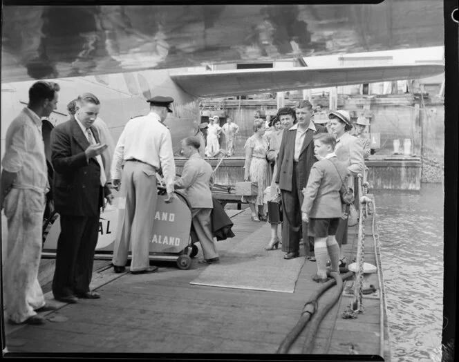 Passengers embarking on the Tasman Empire Airways Ltd Solent seaplane Aotearoa II ZK-AML, Mechanics Bay, Auckland