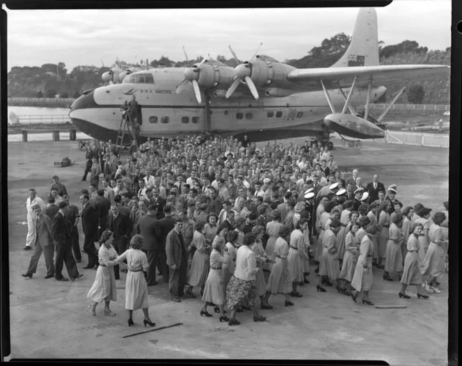 Group of Tasman Empire Airways Ltd staff standing alongside the Solent IV flying boat RMA Awatere, ZK-AMN