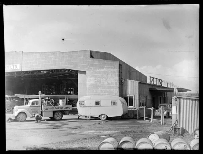 Truck and caravan outside the hangar of Aircraft Service (NZ) Ltd, Auckland