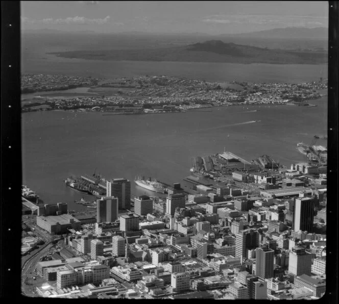 View over Auckland City buildings and wharves towards Devonport and Rangitoto Island