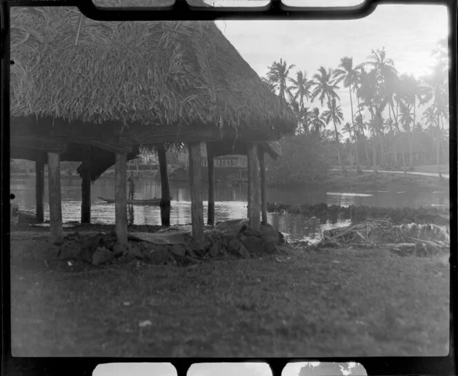 Fale at Faleolo, Apia, Upolu, Samoa, showing unidentified man in boat and road